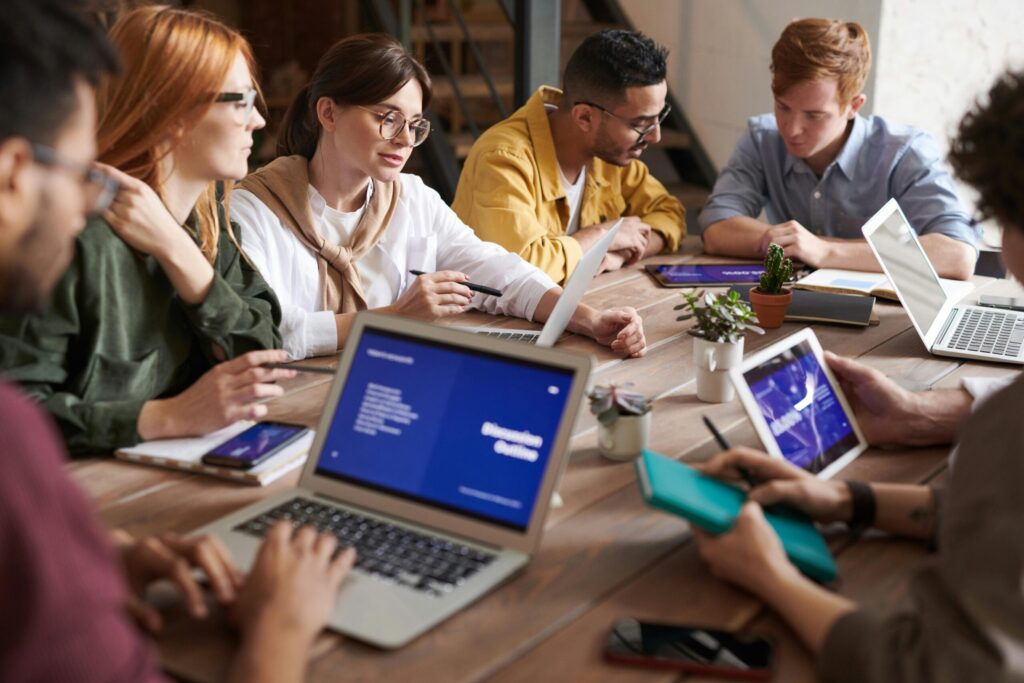 Team collaborating on laptops and tablets during a business meeting