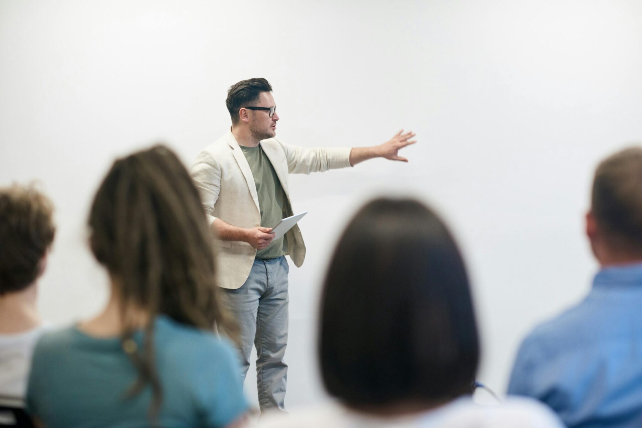 Male speaker giving a presentation to an audience in a classroom or seminar